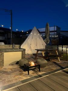 een terras met een vuurplaats en een tent bij BASE 1901 - Vacation STAY 88754v in Minamiboso