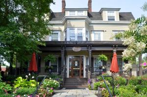 a house with red umbrellas in front of it at The Peacock Inn, an Ascend Collection Hotel in Princeton