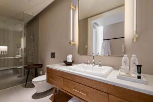 Un baño con lavabo, inodoro y espejo. en Xianju Bieyuan Guesthouse Hotel, en Dali Shuanglang