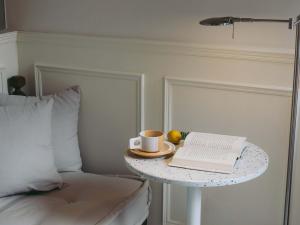 Una cama con una mesa con un libro y una taza de café. en Xianju Bieyuan Guesthouse Hotel, en Dali Shuanglang