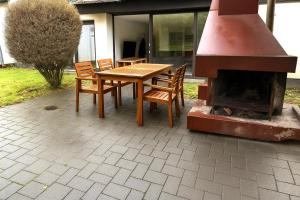 a wooden table and chairs next to a fireplace at Großes Ferienhaus in Siegen-Kreuztal auch für Monteure in Kreuztal