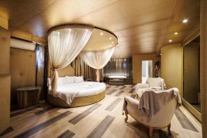 a bedroom with a bed and two chairs and a mirror at Ruby Rooms Kifisia in Athens +124 photos