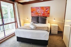 ein Schlafzimmer mit einem Bett und einem großen Fenster in der Unterkunft Karri Birdsong Retreat in Margaret River Town