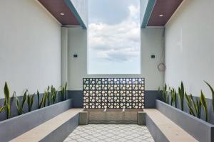 a waiting room with a bench and plants at Urbanview Hotel JD Luxury Brebes in Banjararja