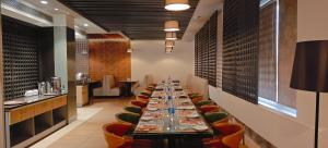 ティルプルにあるThe Mayberry -A Bergamont Group of Hotelsの長いテーブルと椅子のある長いダイニングルーム