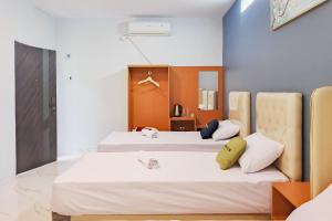 two beds in a room with white sheets at Urbanview Hotel JD Luxury Brebes in Banjararja