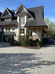 una casa con una entrada para autos en frente de ella en Aparthotel Bellamonte, en Zakopane