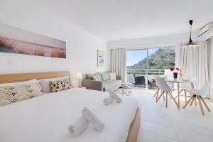 ein weißes Schlafzimmer mit einem Bett und einem Tisch und Stühlen in der Unterkunft Siesta style in Port d'Alcúdia