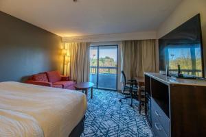 a hotel room with a bed and a couch and a desk at Country Inn & Suites by Radisson, Convention Center in Altoona +215 photos