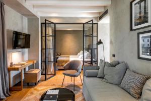 ein Wohnzimmer mit Sofa und ein Schlafzimmer in der Unterkunft Il Mansio Vegan Hotel and Restaurant in Desenzano del Garda