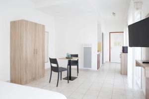 una cucina con un tavolo e sedie in una stanza di Comfort Aparthotel Divonne La Versoix a Divonne-les-Bains