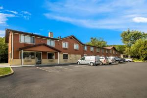 a building with cars parked in a parking lot at Rodeway Inn Delmont in Delmont