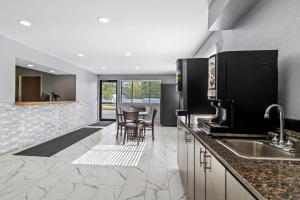 a kitchen with a sink and a table with chairs at Rodeway Inn Delmont in Delmont