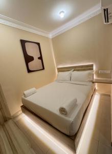 a bed in a room with lights on the floor at Blenz Hotel in Serdang