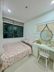 une chambre avec un lit, un bureau et un miroir dans l'établissement Minh Anh Apartment 3, à Thôn An Hòa