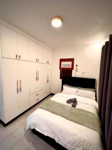 a bedroom with a bed with a cat laying on it at RKs Cozy Balai in General Santos