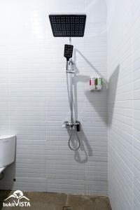 eine Dusche im Bad mit weißen Fliesen in der Unterkunft Amberley Hill Villa by Bukit Vista in Uluwatu