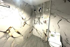 a bathroom with a toilet and a marble wall at Jomtien Wave Residence in Jomtien Beach +51 photos