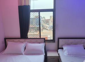a bedroom with two beds and a window at hotel pink city in Rīngas
