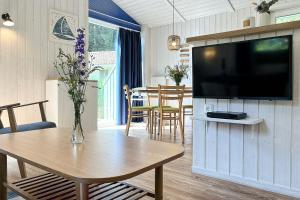 a living room with a table and a flat screen tv at Schatzkiste - Dorf Ferienhaus 4a in Priwall