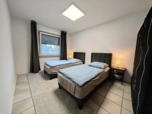 a bedroom with two beds and a window at Gästehaus Wohnung #3 in Jülich