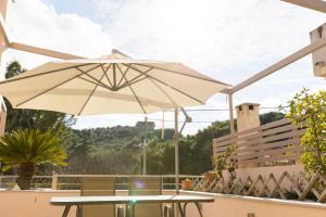 a patio with a table and an umbrella at Vasso Villa in Vravrona
