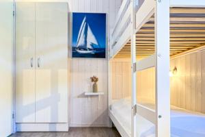 a bedroom with a bunk bed and a ladder at Schatzkiste - Dorf Ferienhaus 18 in Priwall