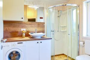 a bathroom with a washing machine and a sink at Schatzkiste - Dorf Ferienhaus 18 in Priwall +50 photos