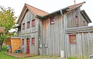 a large wooden building with red windows and red doors at Ferienwohnung mit Dachterrasse Kamin nahe dem Strelasund in Franken Vorstadt