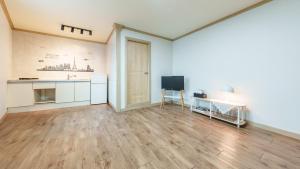 een lege kamer met een keuken en een televisie bij Sokcho Dderak Pension in Sokcho +13 foto's