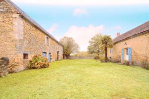 an empty yard between two brick buildings at Gite La Bessede - Dordogne in La Chapelle-Aubareil