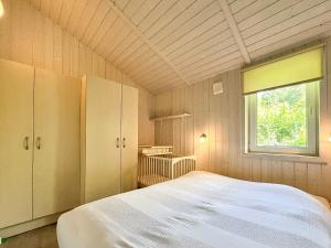 a bedroom with a large bed and a window at Schatzkiste - Dorf Ferienhaus 08 in Priwall