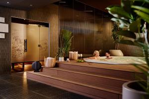 Dos personas en una bañera en un baño. en Arba Resort, Valamar Collection, en Rab