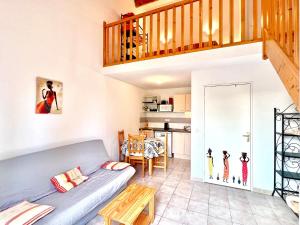 a living room with a blue couch and a staircase at Panorama du mas, 2 Pers Piscine à Calvisson in Calvisson