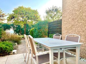 a white table and chairs on a patio at Panorama du mas, 2 Pers Piscine à Calvisson in Calvisson