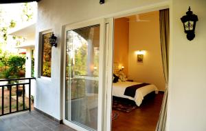 a room with a balcony with a bed and a window at Tranquility Home Stay Coorg in Kutta