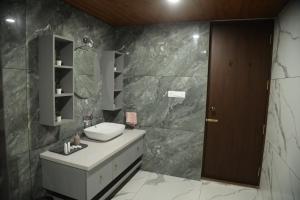 a bathroom with a sink and a mirror at Tranquility Home Stay Coorg in Kutta +14 photos