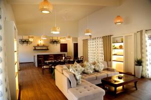 a living room with a couch and a dining room at Tranquility Home Stay Coorg in Kutta