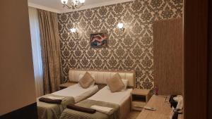 una habitación de hotel con dos camas y un sofá en Sebail inn shah hotel and Shah hostel, en Baku