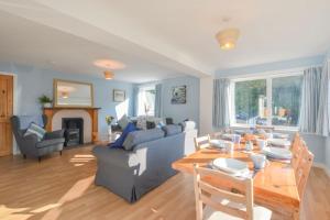 a living room with a couch and a table at Stunning Coastal Home - Garden, Views, Pet Friendly in Connel