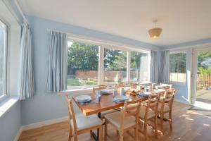 a dining room with a table and some windows at Stunning Coastal Home - Garden, Views, Pet Friendly in Connel