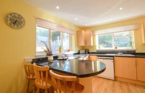 a kitchen with a counter and a clock on the wall at Stunning Coastal Home - Garden, Views, Pet Friendly in Connel