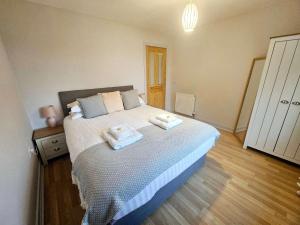 a bedroom with a bed with two towels on it at Stunning Coastal Home - Garden, Views, Pet Friendly in Connel +27 photos