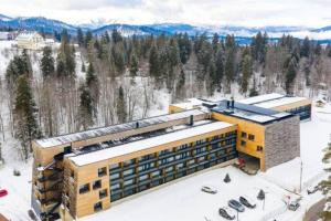 an aerial view of a resort building in the snow at 1BR apart 1 min from M Kokhta 3rd floor in Bakuriani