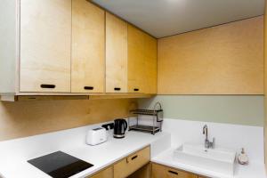 a kitchen with a sink and wooden cabinets at 1BR apart 1 min from M Kokhta 3rd floor in Bakuriani +5 photos