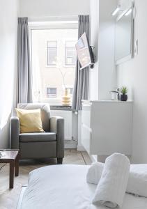 ティルブルフにあるCozy, Simple, And Affordable For Solo Travelerの白いリビングルーム(ソファ、椅子付)