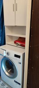 a washing machine with a white cabinet above it at CheapStayVilnius in Vilnius