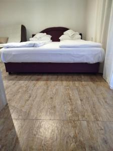 a bedroom with two beds and a wooden floor at Lela in Jošanička Banja