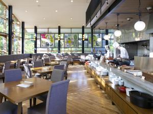 a restaurant with wooden tables and chairs and a chef preparing food at Hakone Retreat Före in Hakone