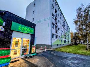 a building with a store on the side of it at Apartament IRESTAN - Komfortowy wypoczynek w sercu Karkonoszy in Jelenia Góra
